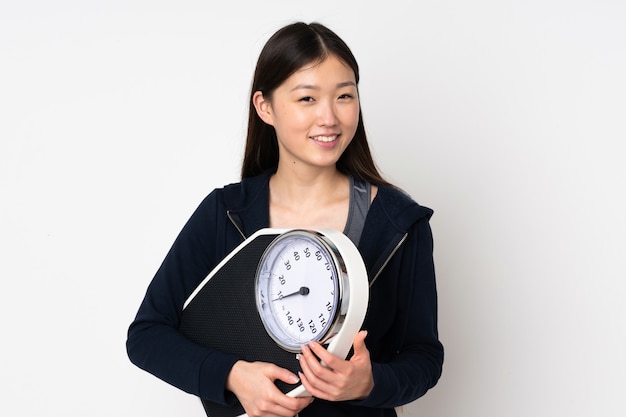 Young woman on white with weighing machine