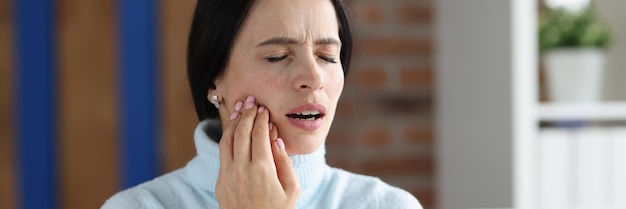 Young woman with acute toothache on couch inflammation of gums and problem with teeth concept