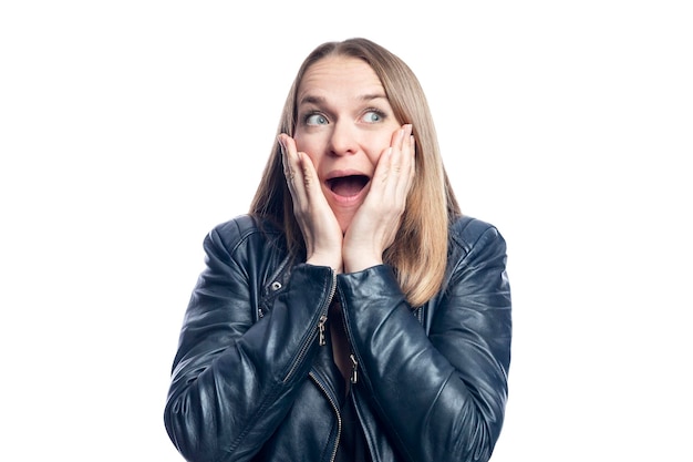 A young woman with an astonished face in a black leather jacket Isolated on white background Closeup