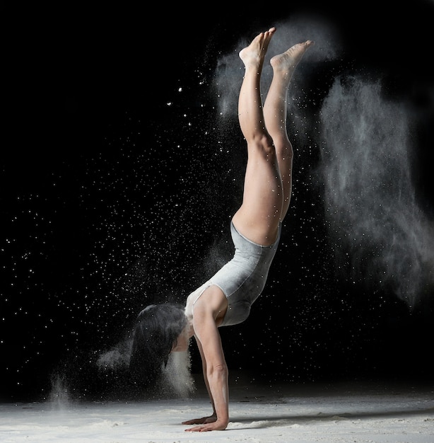 Young woman with an athletic figure  stands upside down on her hands