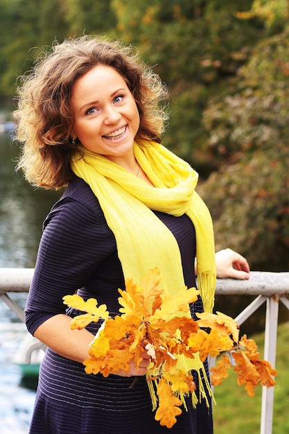 Young woman with autumn leaves in park