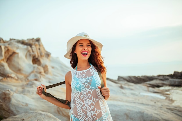 Young woman with a backpack standing at the beach