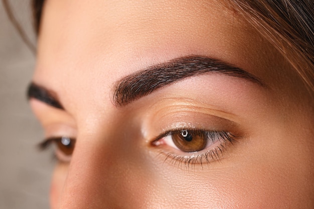 Young woman with beautiful eyebrows after correction, closeup