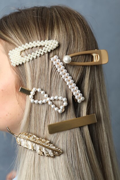 Photo young woman with beautiful hair clips on blue background closeup