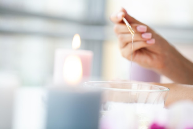 Young woman with beautiful hands putting some wax on them to remove all their hair