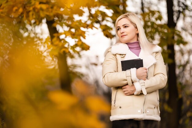 Young woman with a Bible in the alley of park