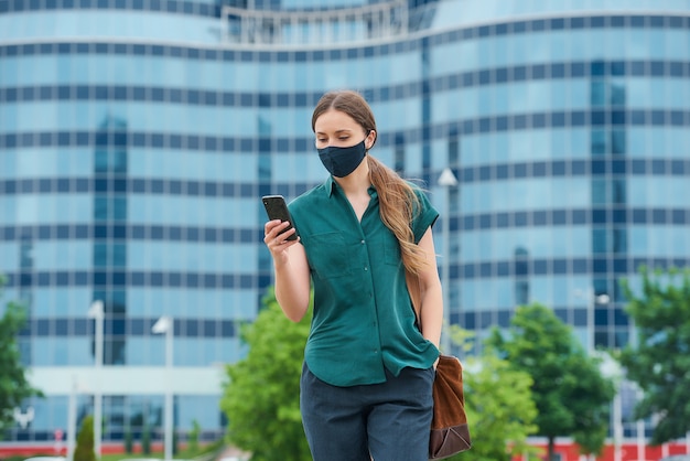 Young woman with a black face mask in the city