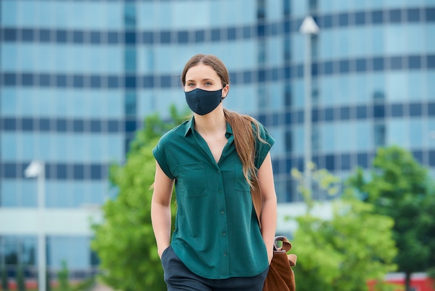 Young woman with a black face mask in the city