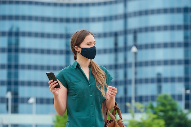 Young woman with a black face mask in the city