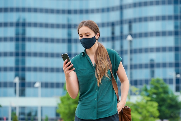 Young woman with a black face mask in the city