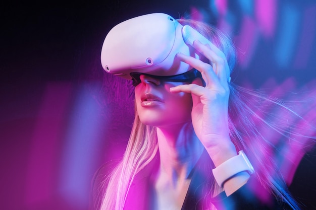 Young woman with blond hair in a vr helmet looks around with surprise and delight