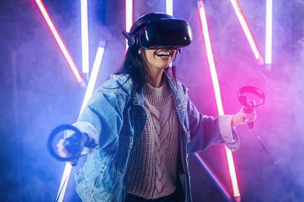 Young woman with blue denim jacket using virtual reality glasses