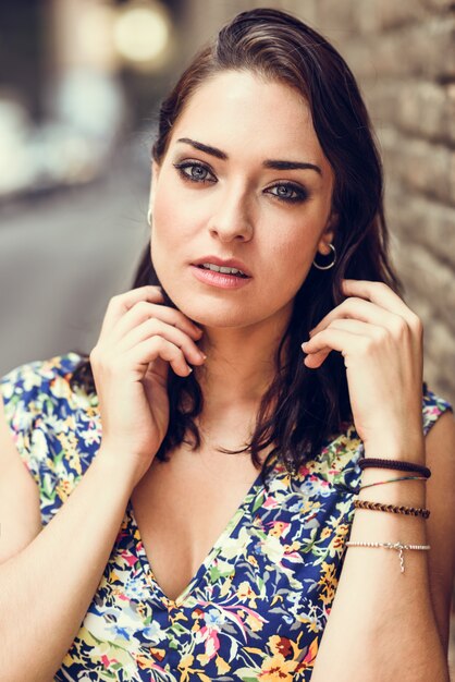 Young woman with blue eyes standing next to brick wall