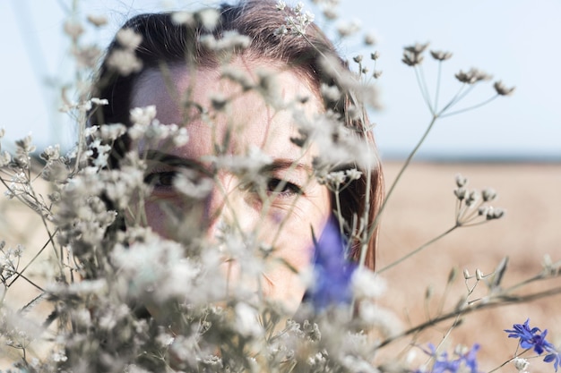 Young woman with a bouquet of wild flowers in the field.