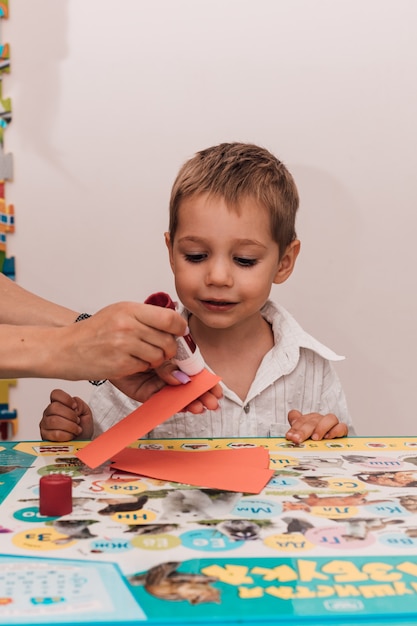 Young woman with boy glue the craft