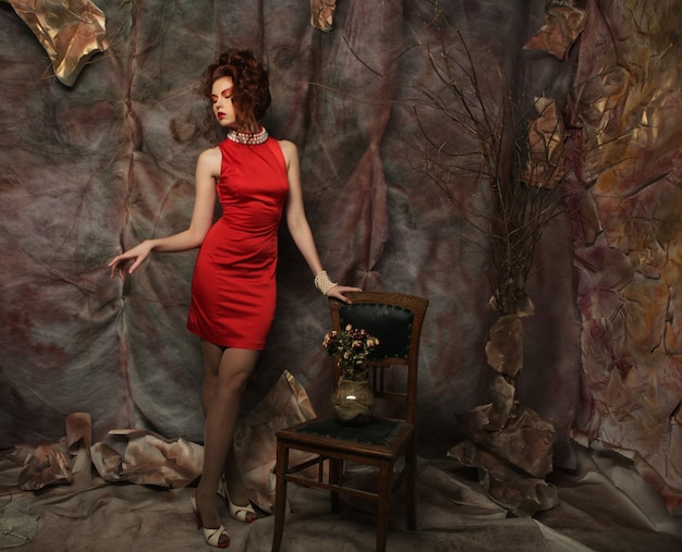 Young woman with bright make-up wearing red dress