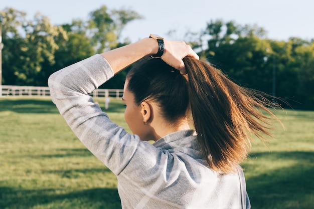 Young woman with brown hair in a sunny park