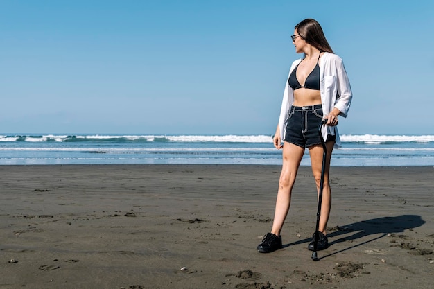 Young woman with cane looking at the sea