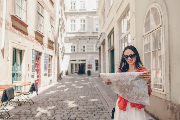 Young woman with a city map in city. Travel tourist girl with map in Vienna outdoors during holidays in Europe.