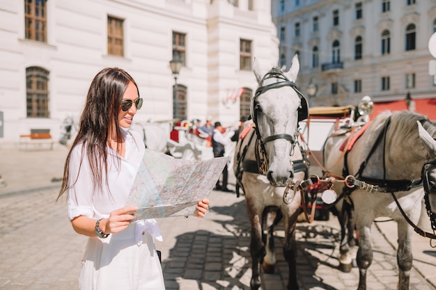 Photo young woman with a city map in the city.