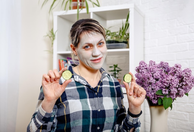 Young woman with cleansing mask on her face at home skin care