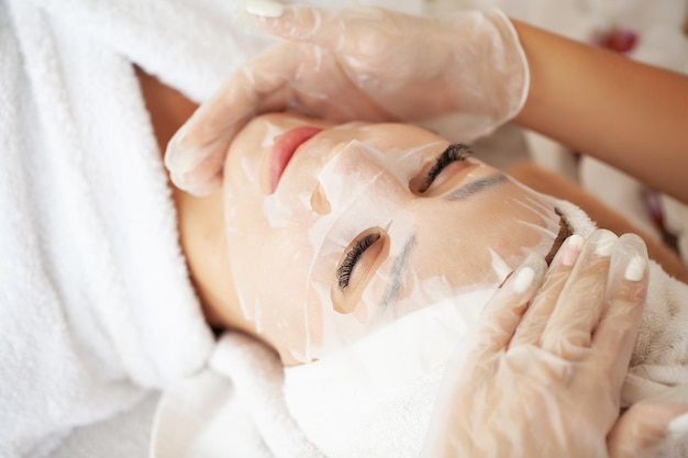 Young woman with cloth mask at spa salon