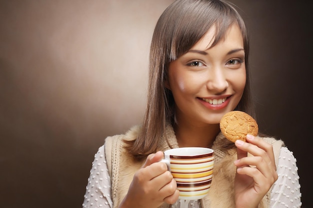 Young woman with coffee and cookies