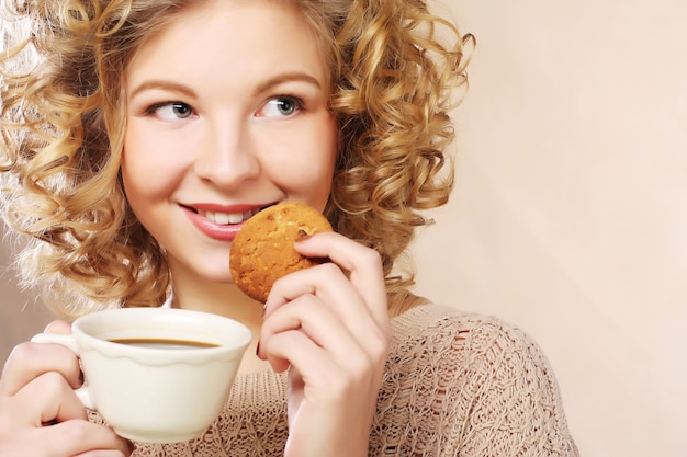 Young  woman with coffee and cookies.