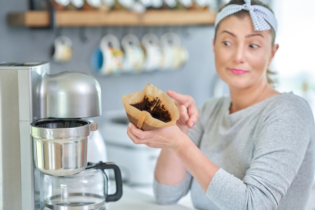 Young woman with coffee grounds use it for peeling