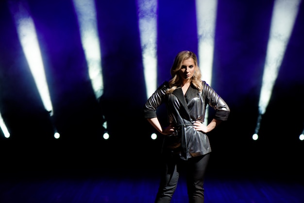 Young woman with colorful lights on concert on the stage