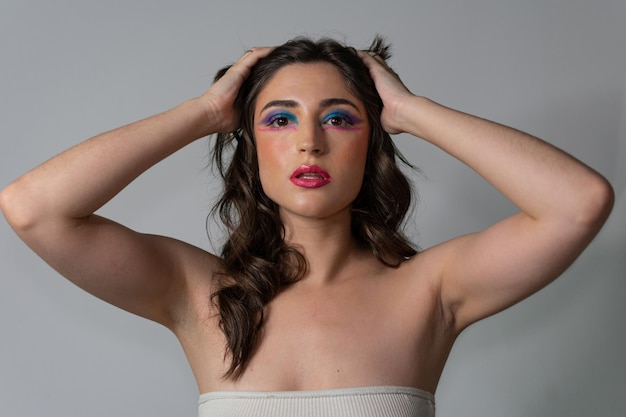 Young woman with creative eyebrows on grey background