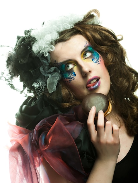 Young woman with creative makeup with cake