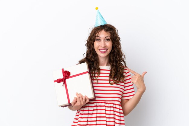 Young woman with curly hair holding present isolated on white background giving a thumbs up gesture