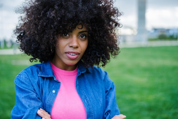 Young woman with curly hair style posing outdoors lifestyle