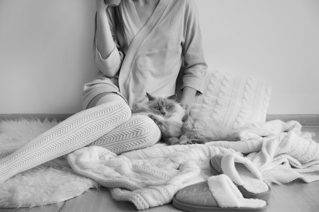 Young woman with cute funny cat resting at home