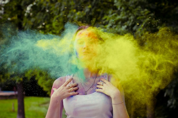 Young woman with dry colored powder falls on her