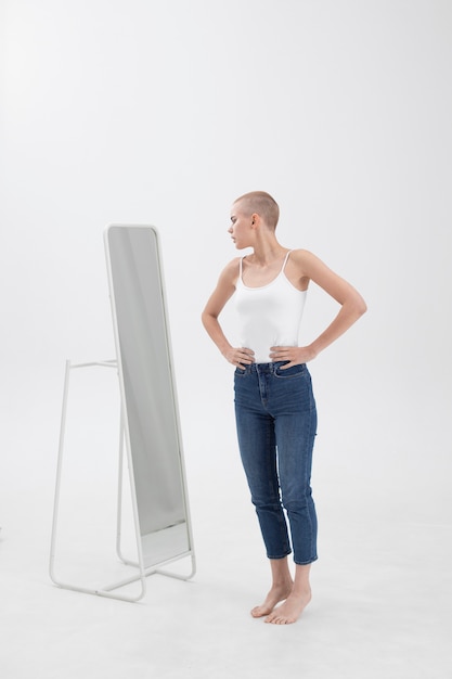 Young woman with an eating disorder checking herself in the mirror