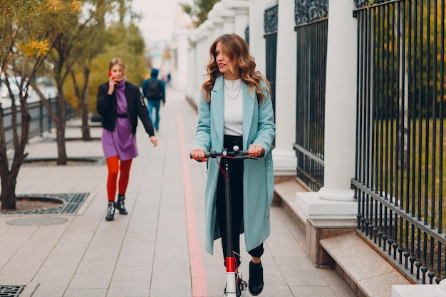 Young woman with electric scooter at the city