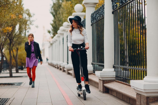 Young woman with electric scooter at the city