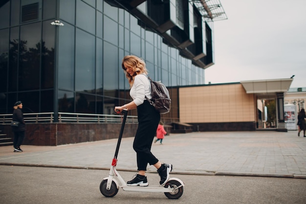 Young woman with electric scooter at the city