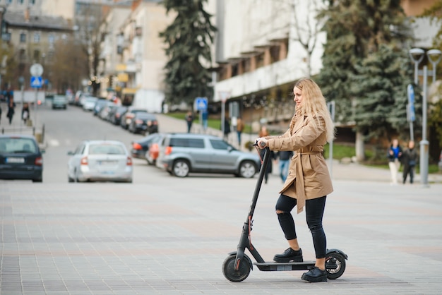 Young woman with electric scooter in the city