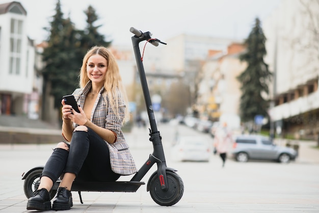 Young woman with electric scooter in the city