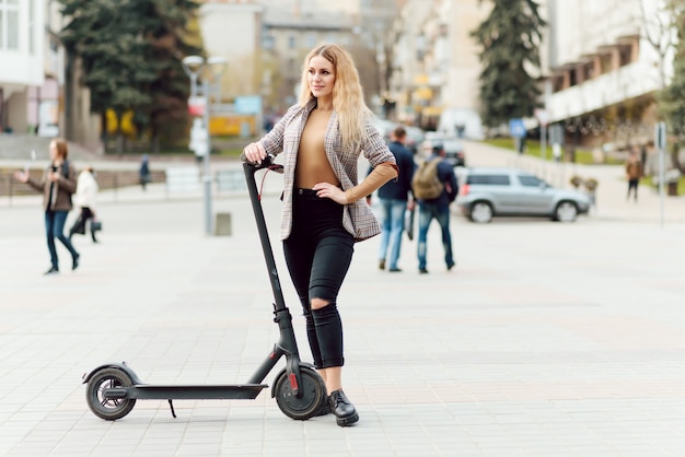 Young woman with electric scooter in the city