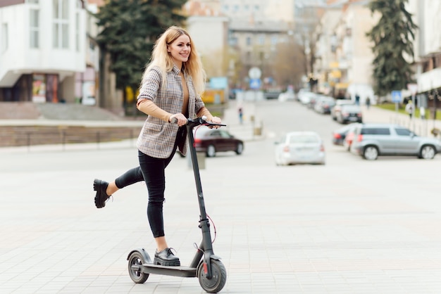 Young woman with electric scooter in the city