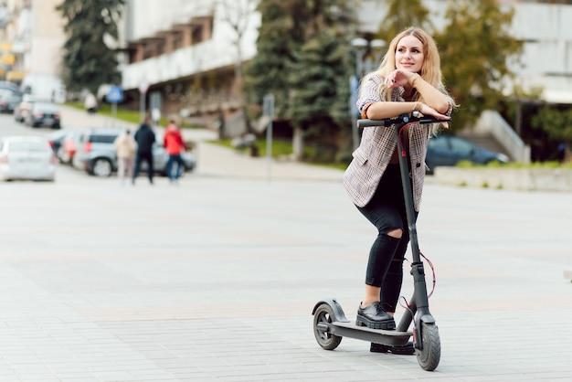 Young woman with electric scooter in the city