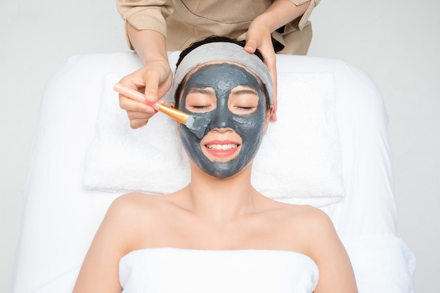 Young woman with facial mask in beauty salon