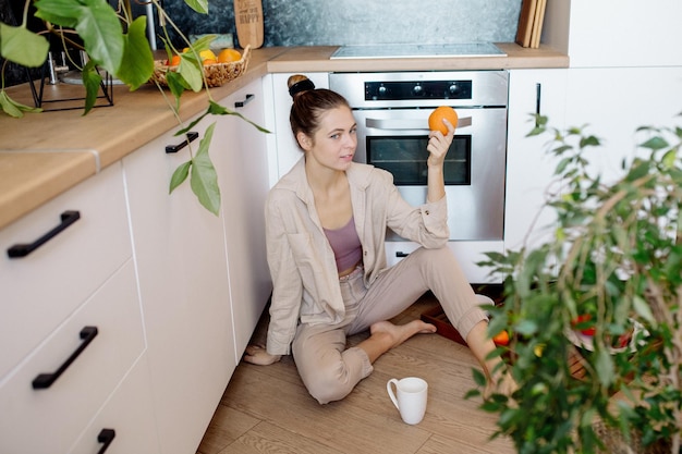 Young woman with fruits in the kitchen Healthy vegan food at home