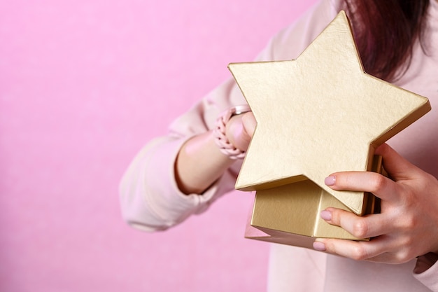 A young woman with a gift box in her hands