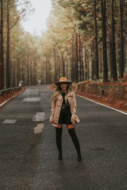 Young woman with hat in the field looking at the camera