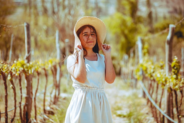 Young woman with hat in a vineyard